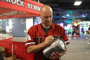 John Holmberg host of 98 KUPD's Morning Sickness autographing a mini Easter Keg Trophy 