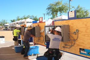 Electricians are competing in the wire-off, each has a metal box and a lot of qires an
