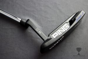 Engraved handle on the foot of the golf club. 