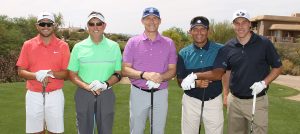Desert Classic Golf Tournament attendees posing with their golf clubs on the golf course.