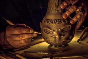 Odd Rodney's hand shot sculpting the Deadhead Rum shrunken head bottle.