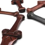 Five copper sword prototypes lying in a circle with handles in the middle.