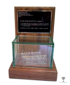 Display case holding a prototype with a plaque engraved by Tempe Trophy.