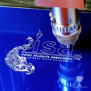 Indian Students Association logo being engraved on a plate.